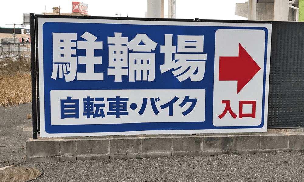 野外壁に設置された駐輪場のアルポリパネル案内看板